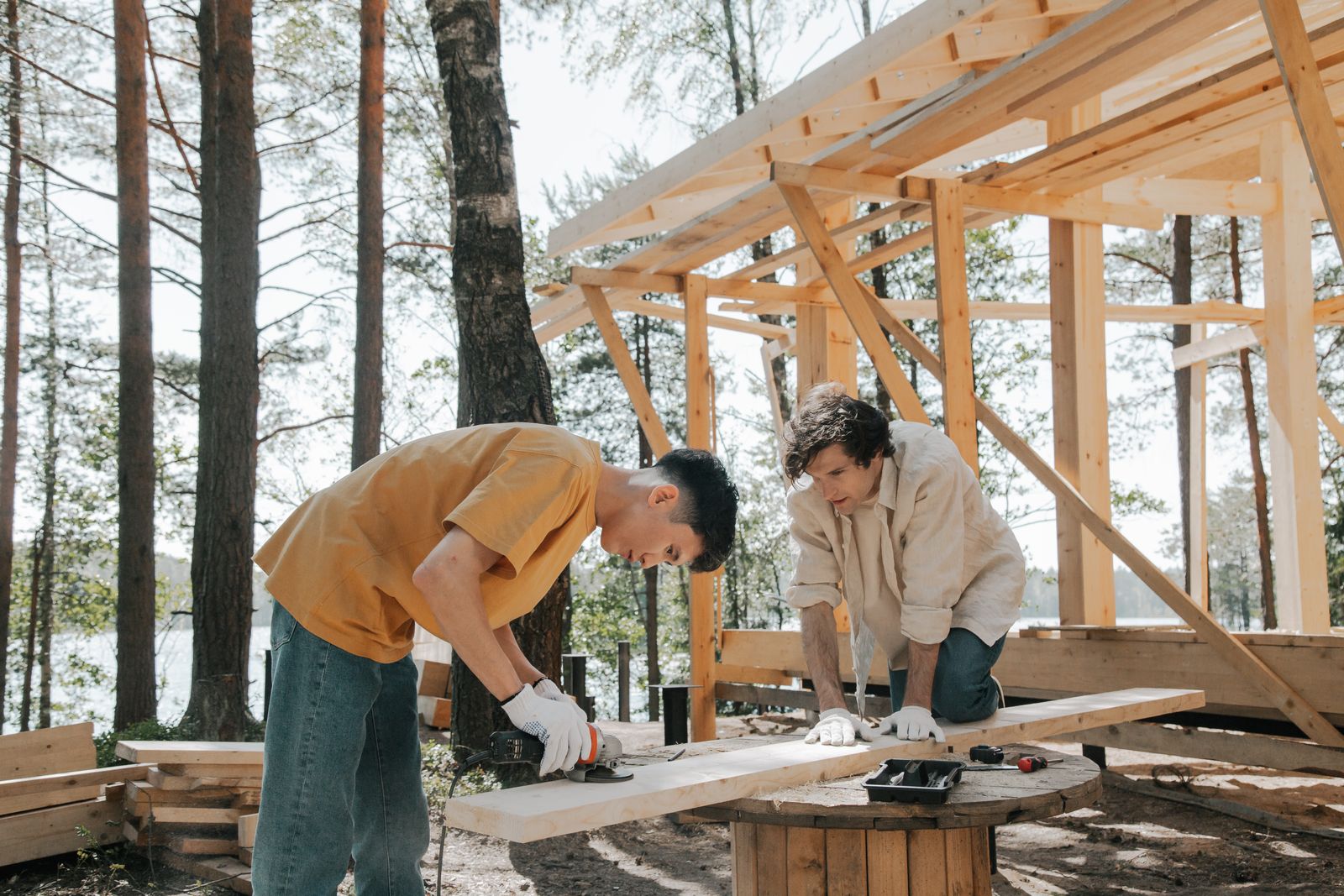 職人二人が木造の骨組みを建てているところ